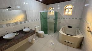 a bathroom with a shower and a sink and a toilet at Biazi Paradise Hotel in Serra Negra