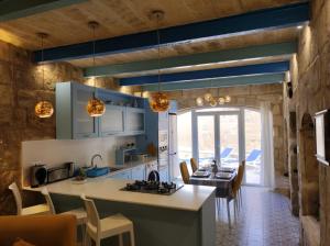 a kitchen and dining room with a table and chairs at Il Hnejja Farmhouse in Mqabba