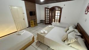 a bedroom with two beds and a television in it at Biazi Paradise Hotel in Serra Negra