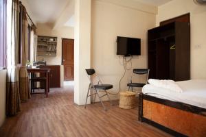 a bedroom with a bed and two chairs and a desk at Hotel Northfield in Kathmandu