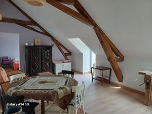 ein Schlafzimmer mit einem Bett und Stühlen im Dachgeschoss in der Unterkunft Les Chaumes Violettes in Cluis