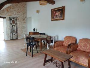 ein Wohnzimmer mit einem Tisch und Stühlen in der Unterkunft Les Chaumes Violettes in Cluis