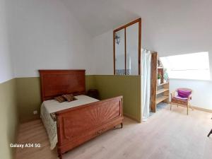Schlafzimmer mit einem Bett, einer Kommode und einem Spiegel in der Unterkunft Les Chaumes Violettes in Cluis