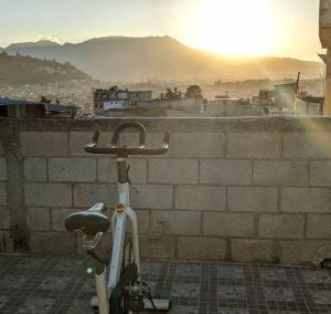 a bike parked next to a brick wall with the sunset at Apartment in Colonia Molina in Quetzaltenango