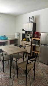 a kitchen with a table and chairs and a refrigerator at Apartment in Colonia Molina in Quetzaltenango