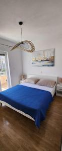 a bedroom with a large bed with a blue blanket at Apartments Kapetanovi Dvori in Trogir