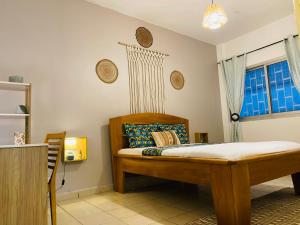 een slaapkamer met een bed en een raam bij Appartement ethnique cosy in Douala