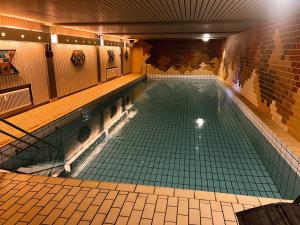 una grande piscina con piastrelle verdi in un edificio di Schwarzwaldausblick - Umweltfreundlich & Pool a Baiersbronn
