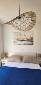 um quarto com uma cama azul e um quadro de veleiros em Apartments Kapetanovi Dvori em Trogir