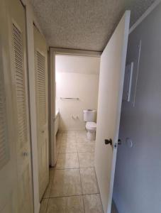 une salle de bains vide avec toilettes et couloir dans l'établissement Presidential Golfview Condominiums, à West Palm Beach