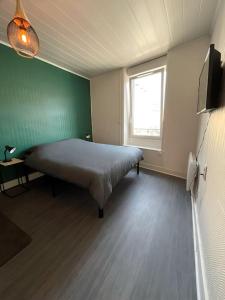 1 dormitorio con cama y pared verde en T2 splendide, 3 min gare Mulsant, en Roanne