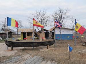 um barco em exposição com bandeiras em frente a um edifício em Camping Letea Himalaya em Letea