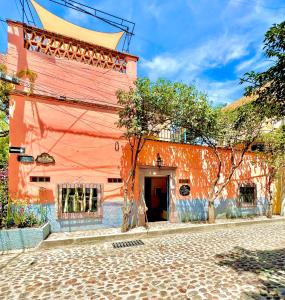 an orange building on a cobblestone street at Boutique Hotel Casa Camellia in San Miguel de Allende +113 photos