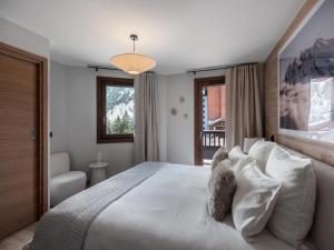 a bedroom with a large bed with white pillows at Résidence Goyard - Chalets pour 12 Personnes 184 in Courchevel