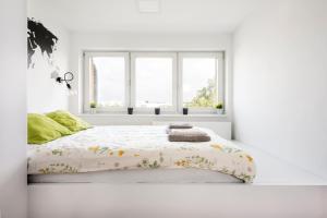 - une chambre blanche avec un lit doté d'un couvre-lit fleuri dans l'établissement Podgórze Apartment - near Vistula river, City View - by Rentujemy, à Cracovie
