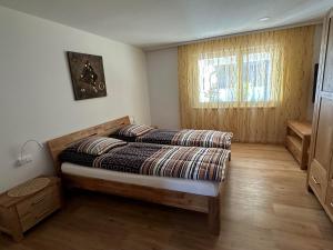 um quarto com uma cama e uma janela em Fewo 68 em Isny im Allgäu