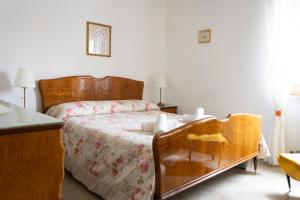 a bedroom with a bed with a wooden headboard at Casa di Nonna Linda in Portocannone