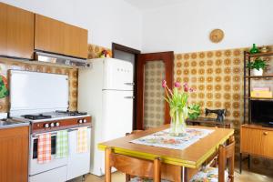 cocina con mesa, estufa blanca y nevera en Casa di Nonna Linda, en Portocannone