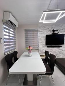 ein weißes Esszimmer mit einem weißen Tisch und Stühlen in der Unterkunft American Standard/2Bedroom House in Cagayan de Oro