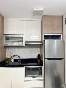 a kitchen with white cabinets and a stainless steel refrigerator at American Standard/2Bedroom House in Cagayan de Oro
