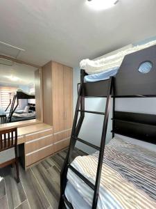 Zimmer mit 2 Etagenbetten und einem Schreibtisch in der Unterkunft American Standard/2Bedroom House in Cagayan de Oro
