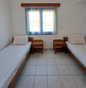 two beds in a room with a window at Melissa Apartments in Frangokastello