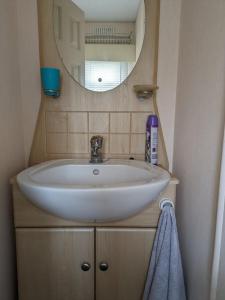 uma casa de banho com um lavatório branco e um espelho. em luxury home from home caravan em Ingoldmells