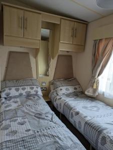 duas camas num pequeno quarto numa caravana em luxury home from home caravan em Ingoldmells