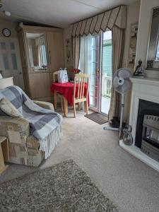 uma sala de estar com uma mesa e uma lareira em luxury home from home caravan em Ingoldmells