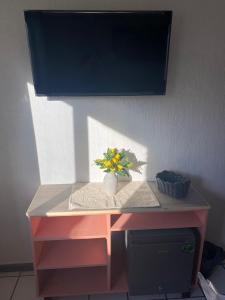 a pink desk with a vase with flowers on it at Casa Dei Girasoli in Cabo San Lucas