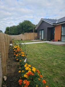 a row of flowers in a yard next to a fence at Hillcrest Home in Hamilton