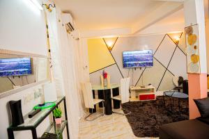 a living room with a table and a tv at Appartement chic et spacieux près centre Yaoundé in Yaoundé