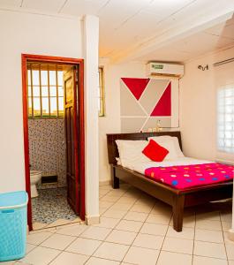 Un dormitorio con una cama con almohadas rojas. en Appartement chic et spacieux près centre Yaoundé, en Yaoundé