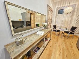 a living room with a table and a mirror at Porta Antica - OldTown Salerno in Salerno