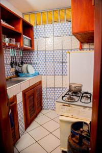 a small kitchen with a stove and a refrigerator at Appartement chic et spacieux près centre Yaoundé in Yaoundé