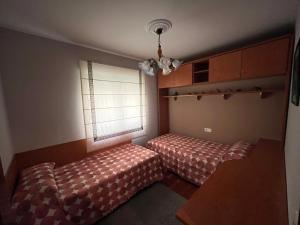 a bedroom with two beds and a window at Alquiler Vacacional en Ribeira in Ribeira