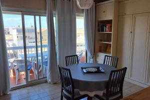 a dining room with a table and chairs and a balcony at Palavas in Palavas-les-Flots