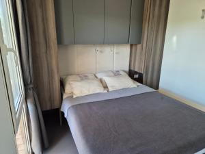 un piccolo letto con due cuscini in una stanza di Luxury Mobile Home Moonwalk Terra Park Spiritos, Pag Island , Kolan a Kolan