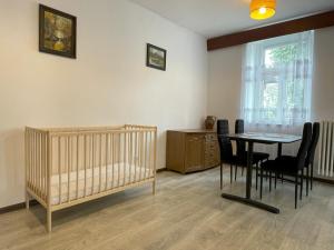 弗次瓦夫的住宿－Apartament 2-pokojowy 55 m2, koło ZOO, Hali Stulecia，一间设有婴儿床和桌椅的房间