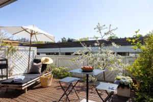 a patio with a table and a bench and an umbrella at Photographers house close to the metro in Espoo