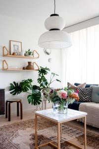 a living room with a table with flowers on it at Photographers house close to the metro in Espoo