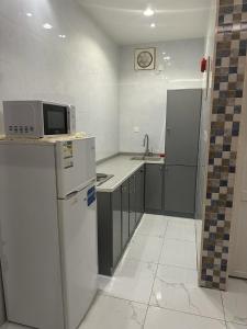 a kitchen with a refrigerator and a microwave at منتجعات الريف بلس in Ḩajlah