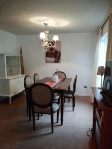 ein Esszimmer mit einem Tisch, Stühlen und einem Kronleuchter in der Unterkunft Casa 3 dormitorios 3 baños Osorno in Osorno