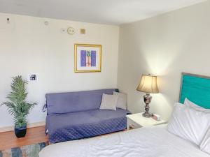 a living room with a couch and a bed at Homey Aqua Palms Studio condo in Honolulu