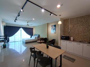 a living room with a table and a bed at Marina Island Lumut HomeHotel in Lumut