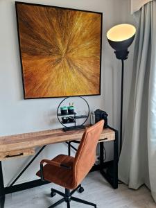 a desk with a chair and a lamp at Lazy Olives in Tongeren