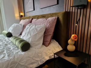 a bed with several pillows on top of it at Lazy Olives in Tongeren