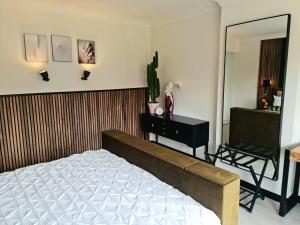 a bedroom with a bed and a mirror and a chair at Lazy Olives in Tongeren