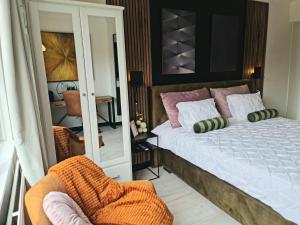 a bedroom with a bed and a chair and a mirror at Lazy Olives in Tongeren