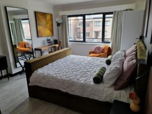 a bedroom with a bed and a large window at Lazy Olives in Tongeren